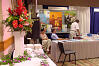 Colorful floral arrangement with 
an exhibit booth in the background.